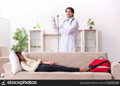 Young handsome doctor visiting female patient at home 