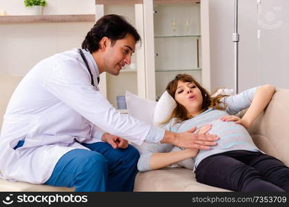 Young handsome doctor visiting pregnant woman at home 