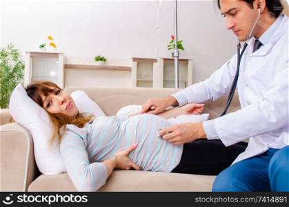 Young handsome doctor visiting pregnant woman at home 