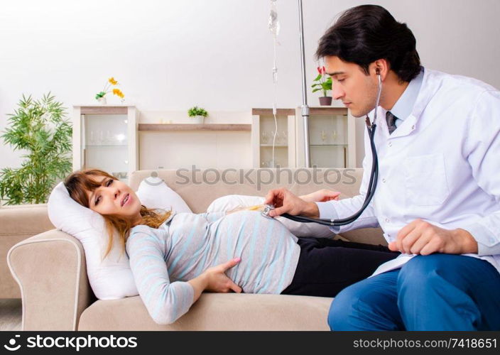 Young handsome doctor visiting pregnant woman at home 