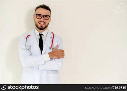 Young handsome doctor with arms crossed standing on white background. Medical and healthcare concept.. Young doctor with arms cross on white background.
