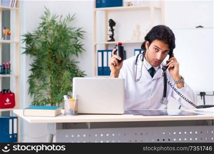 Young handsome doctor working in clinic 