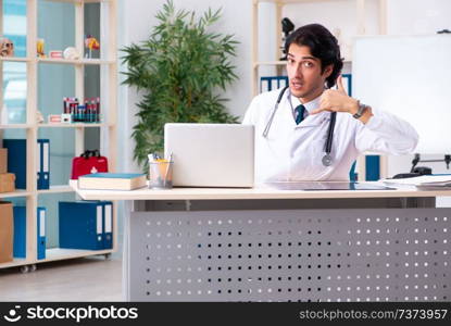 Young handsome doctor working in clinic 