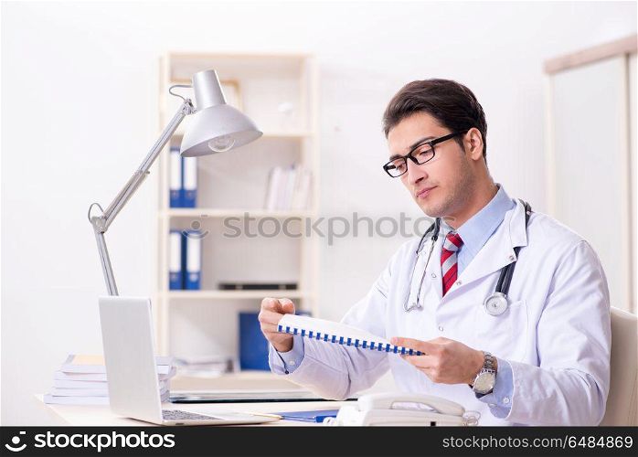 Young handsome doctor working in hospital room