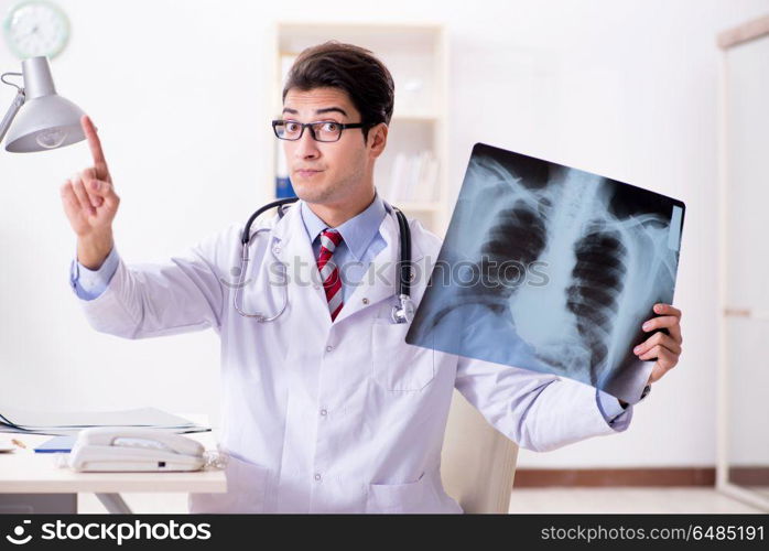 Young handsome doctor working in hospital room