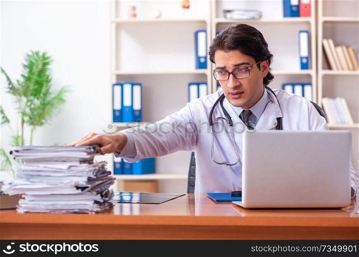 Young handsome doctor working in the clinic 