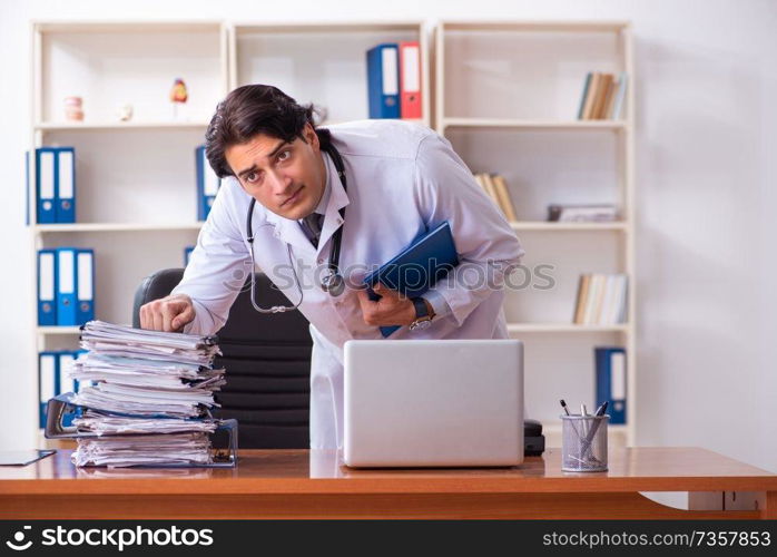 Young handsome doctor working in the clinic 