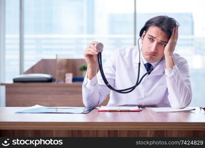 Young handsome doctor working in the clinic 