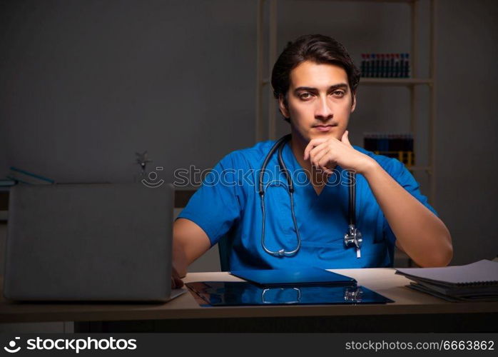 Young handsome doctor working night shift in hospital   