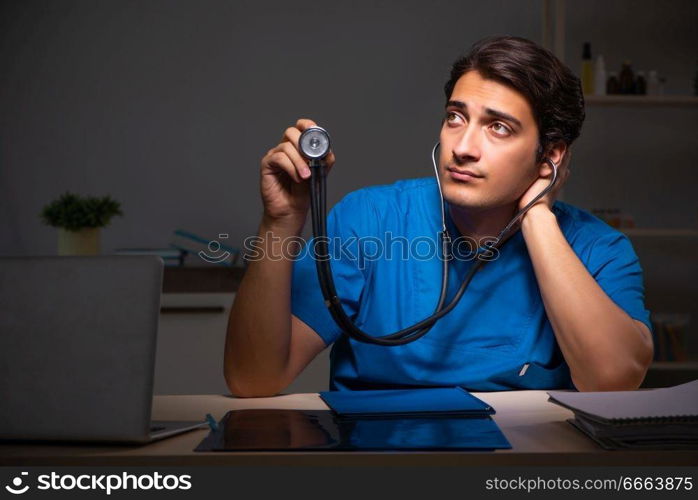 Young handsome doctor working night shift in hospital   