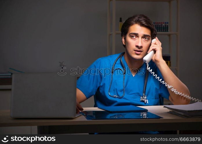 Young handsome doctor working night shift in hospital   