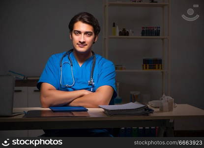 Young handsome doctor working night shift in hospital   