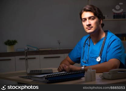 Young handsome doctor working night shift in hospital   