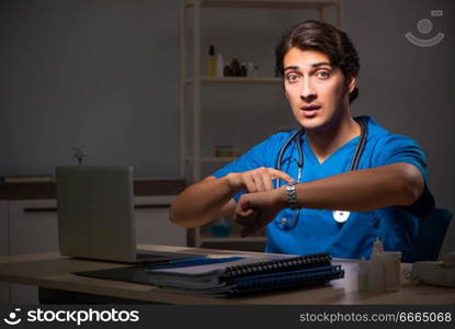 Young handsome doctor working night shift in hospital   