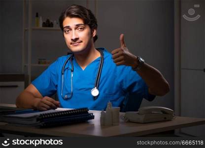 Young handsome doctor working night shift in hospital   