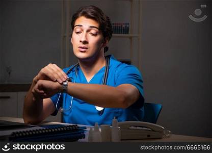 Young handsome doctor working night shift in hospital   