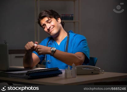 Young handsome doctor working night shift in hospital   