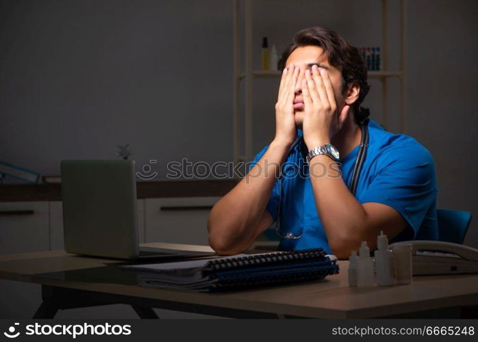 Young handsome doctor working night shift in hospital   