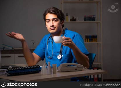 Young handsome doctor working night shift in hospital   