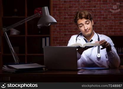 Young handsome doctor working night time at the hospital 