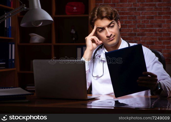 Young handsome doctor working night time at the hospital 