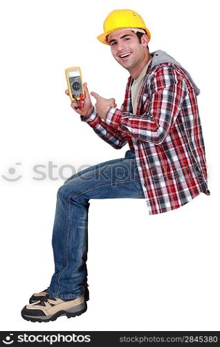 young handsome electrician pointing at tester