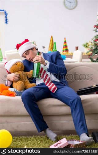 Young handsome employee celebrating Christmas at workplace . The young handsome employee celebrating christmas at workplace 