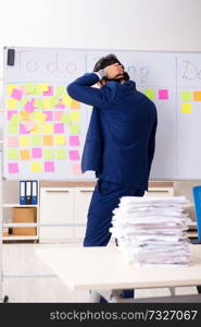 Young handsome employee in front of whiteboard with to-do list  