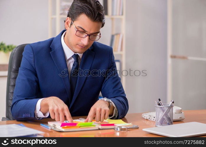 Young handsome employee planning his work activity 