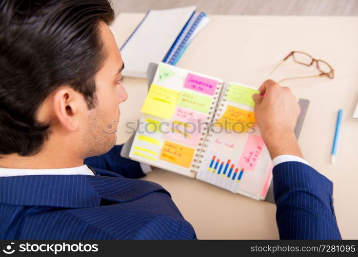 Young handsome employee planning his work activity 