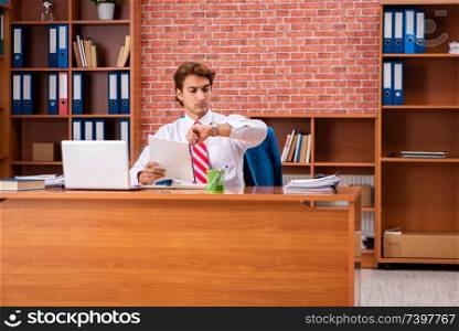 Young handsome employee sitting in the office  