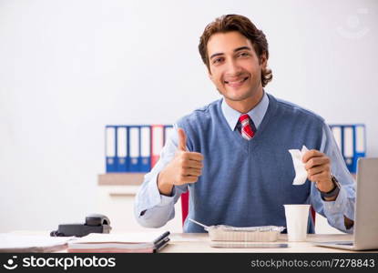 Young handsome employee working in the office 