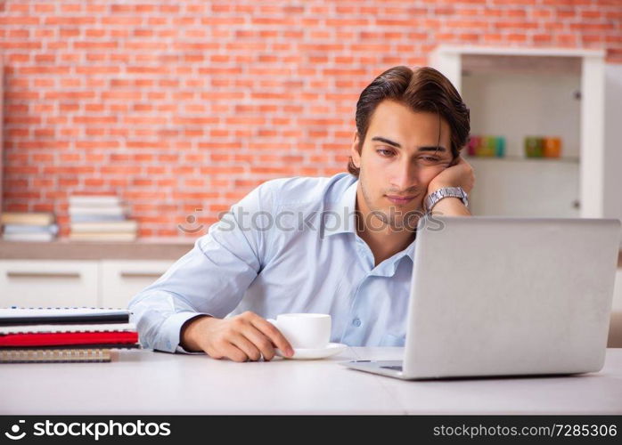 Young handsome employee working in the office 