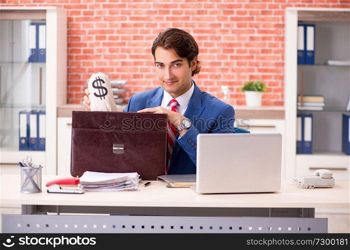 Young handsome employee working in the office 