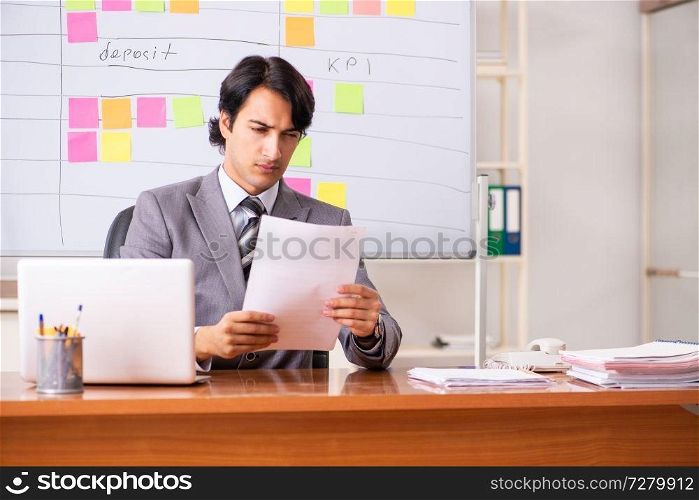 Young handsome employee working in the office . Young handsome employee working in the office