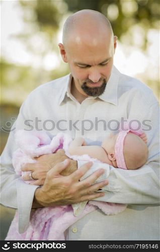 Young Handsome Father Holds His Newborn Baby Girl Outside.