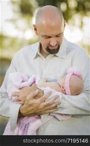 Young Handsome Father Holds His Newborn Baby Girl Outside.