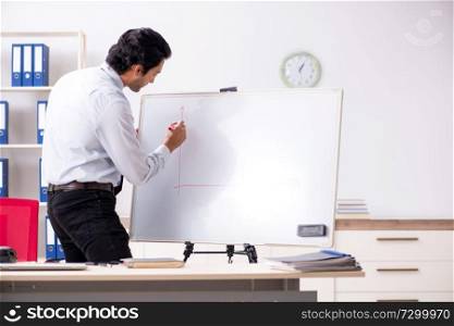 Young handsome financial speciaist in front of white board 