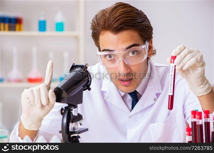 Young handsome lab assistant testing blood s&les in hospital . The young handsome lab assistant testing blood s&les in hospital 