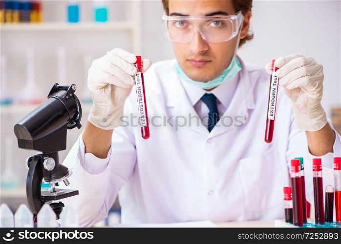 Young handsome lab assistant testing blood samples in hospital 