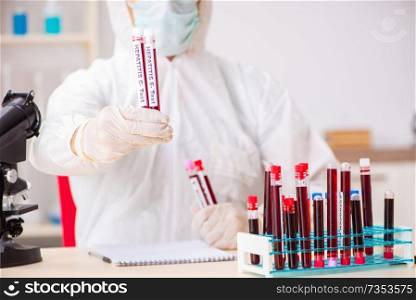 Young handsome lab assistant testing blood samples in hospital