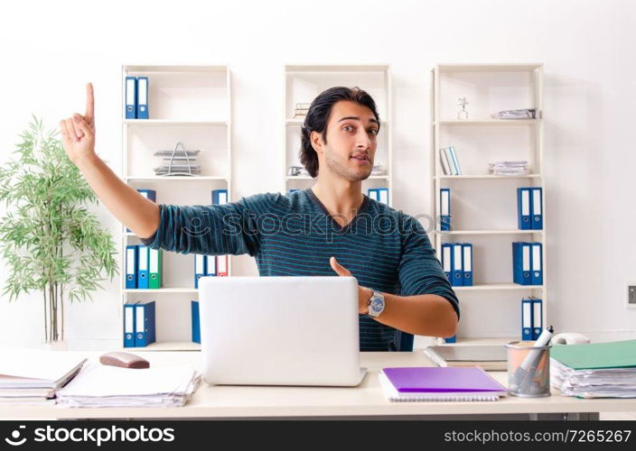 Young handsome male employee sitting at the office