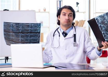 Young handsome male radiologist in front of whiteboard 