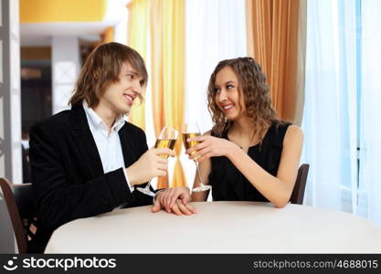 Young handsome man and pretty woman in a restaurant with shampagne