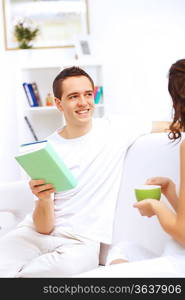 Young handsome man at home with a book