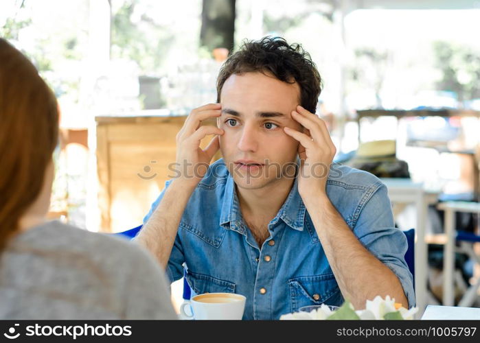 Young handsome man bored at a date in coffee shop.