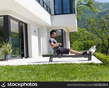 young handsome man doing morning exercises in front of his luxury home villa