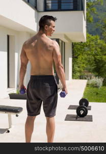 young handsome man doing morning exercises in front of his luxury home villa