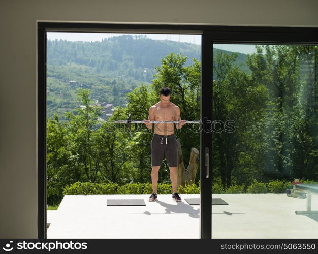 young handsome man doing morning exercises in front of his luxury home villa