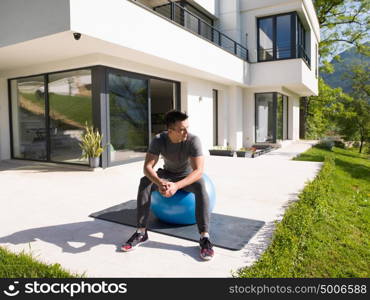 young handsome man doing morning yoga exercises in front of his luxury home villa